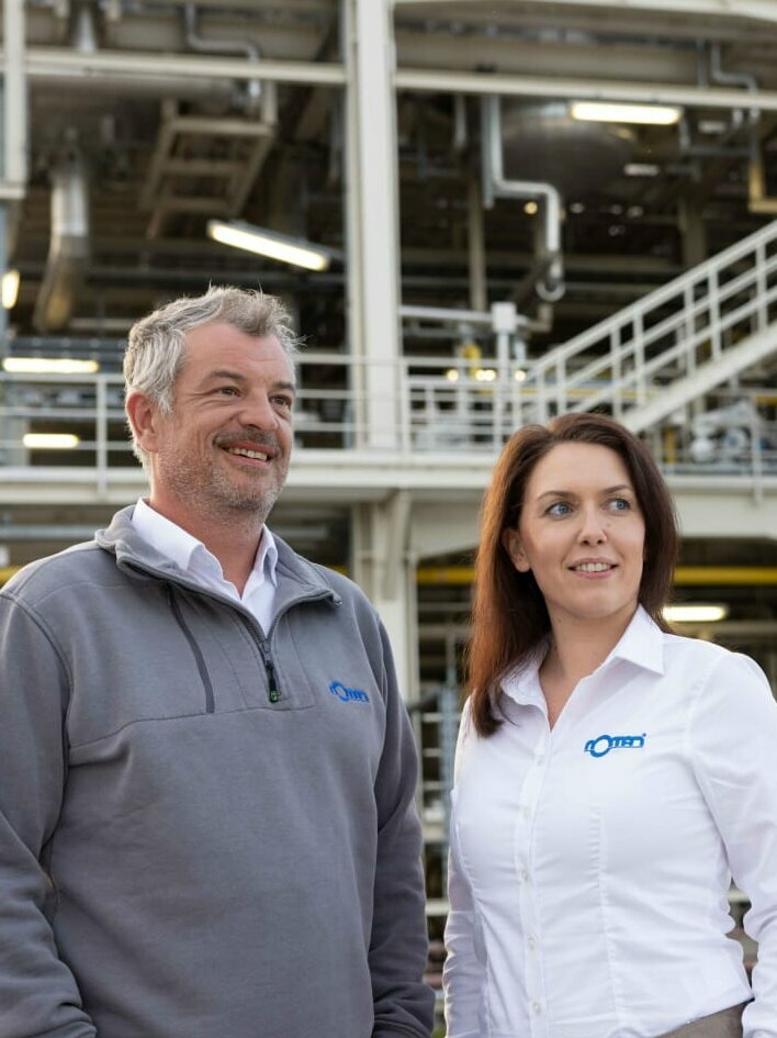 Rotan Geschäftsführer und Prokuristin vor Industrieanlage 